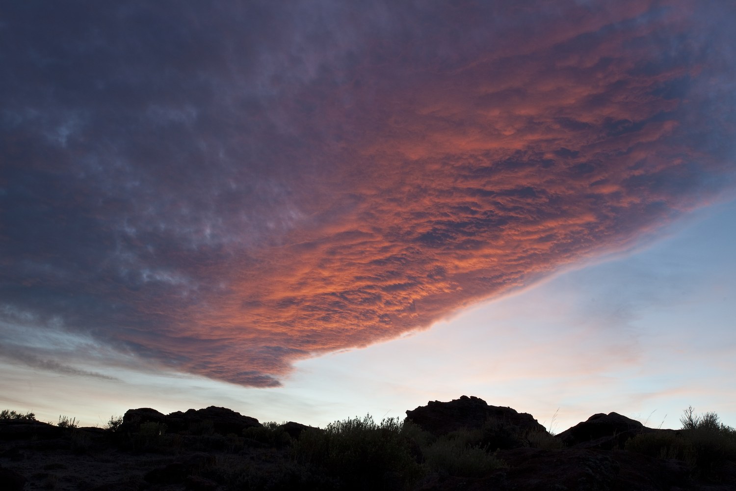 The eroded badlands of Adobe Town under a wide pale sky.
